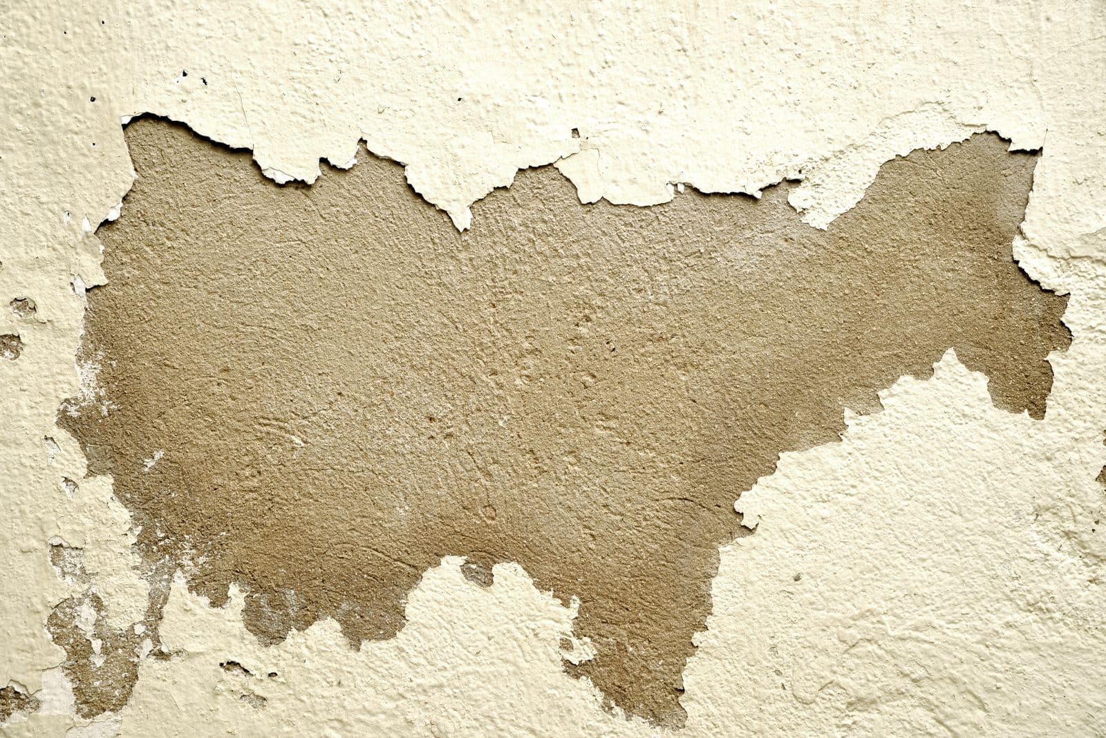 Pared exterior con la pintura desconchada y el enfoscado a la vista