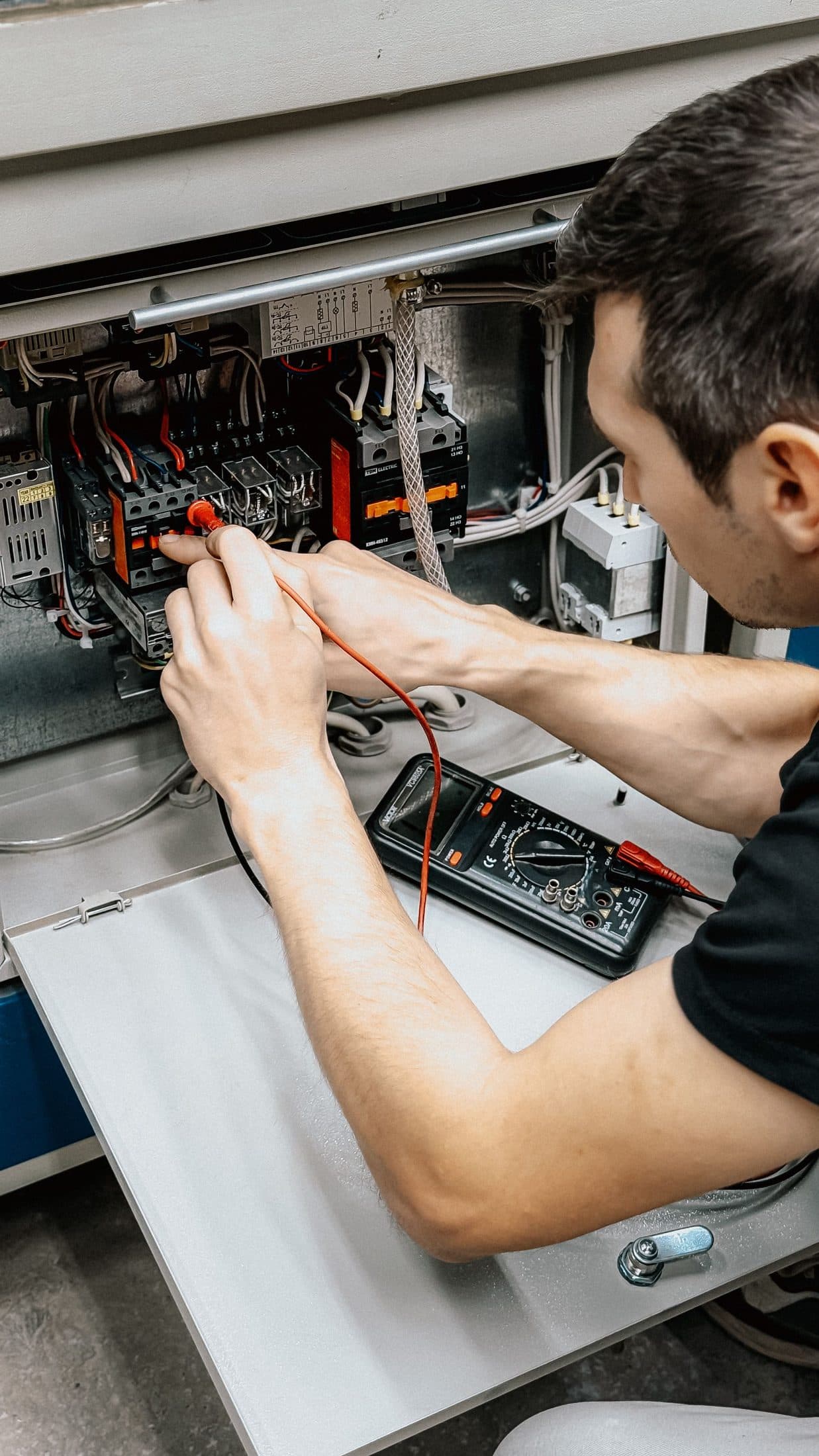 Profesional comprobando una instalación eléctrica con un multímetro