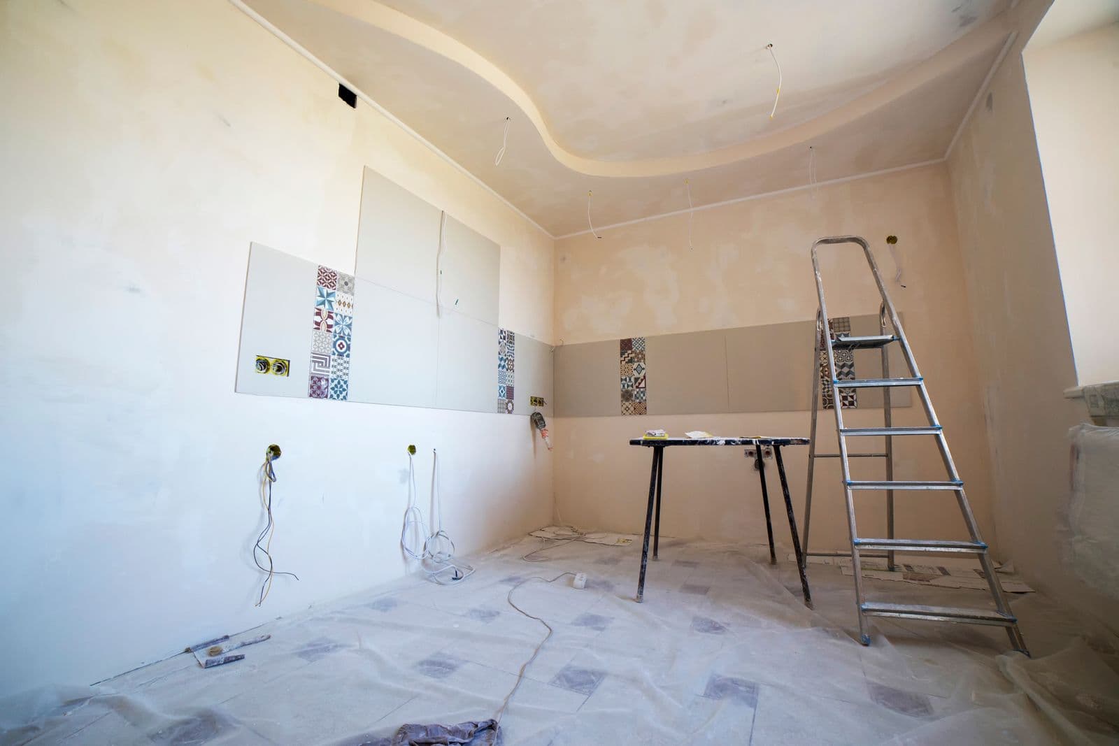 Habitación en obras con una escalera y azulejos de muestra en la pared